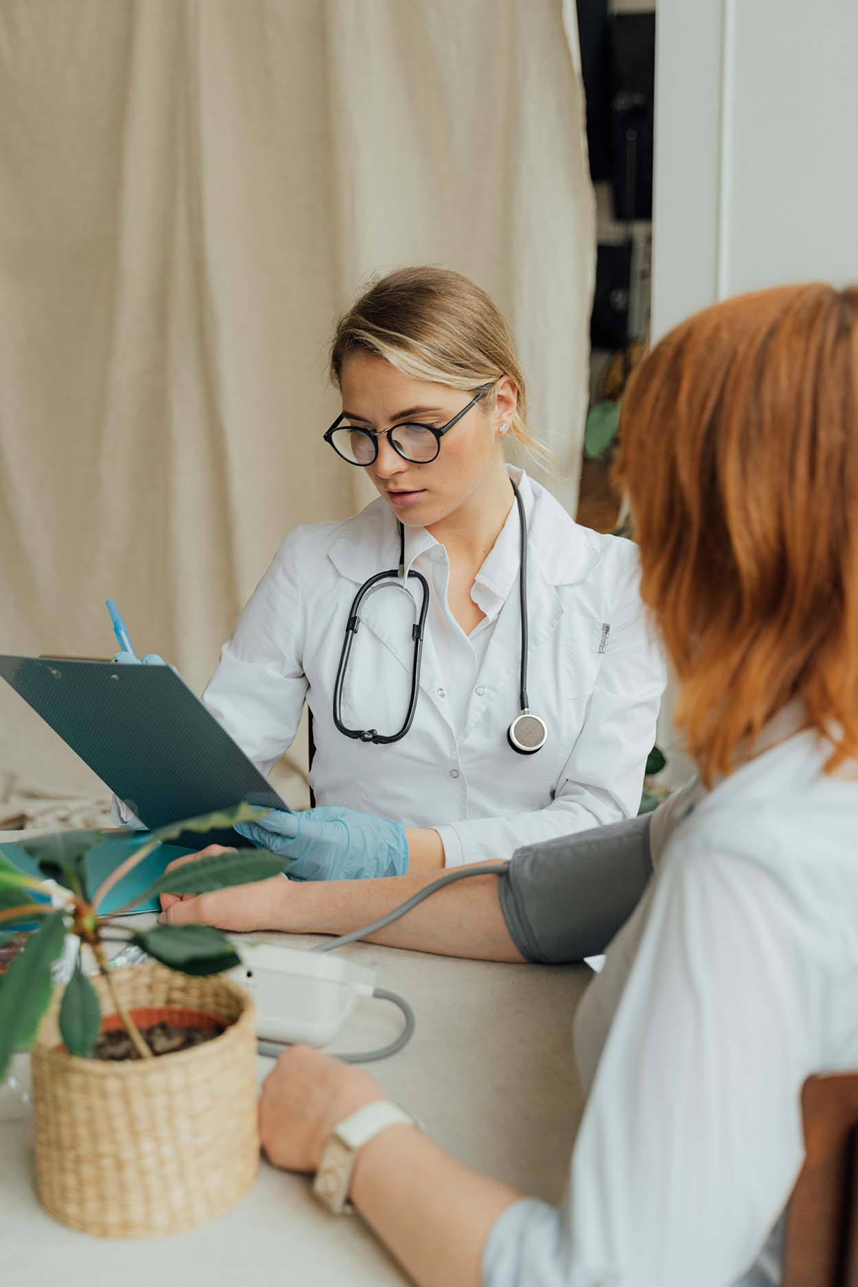 A nurse taking a woman's blood pressure.